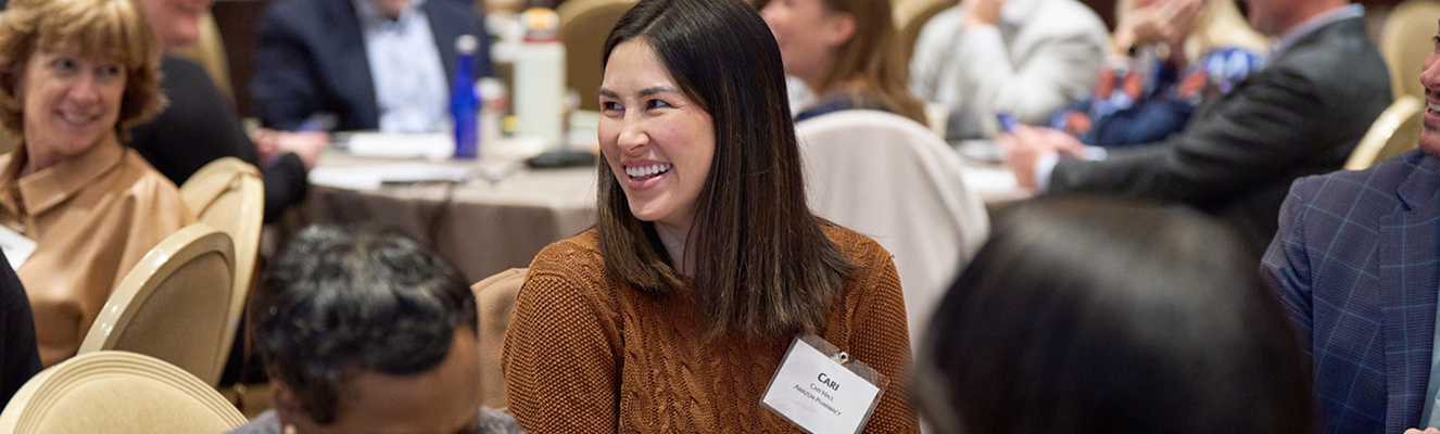 Woman sitting at table in AMCP Conference