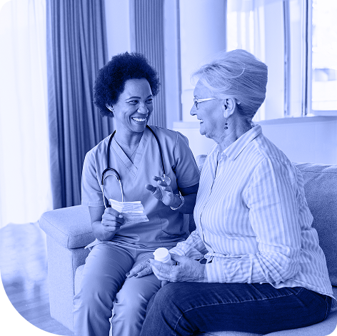 Woman and nurse sitting on couch smiling